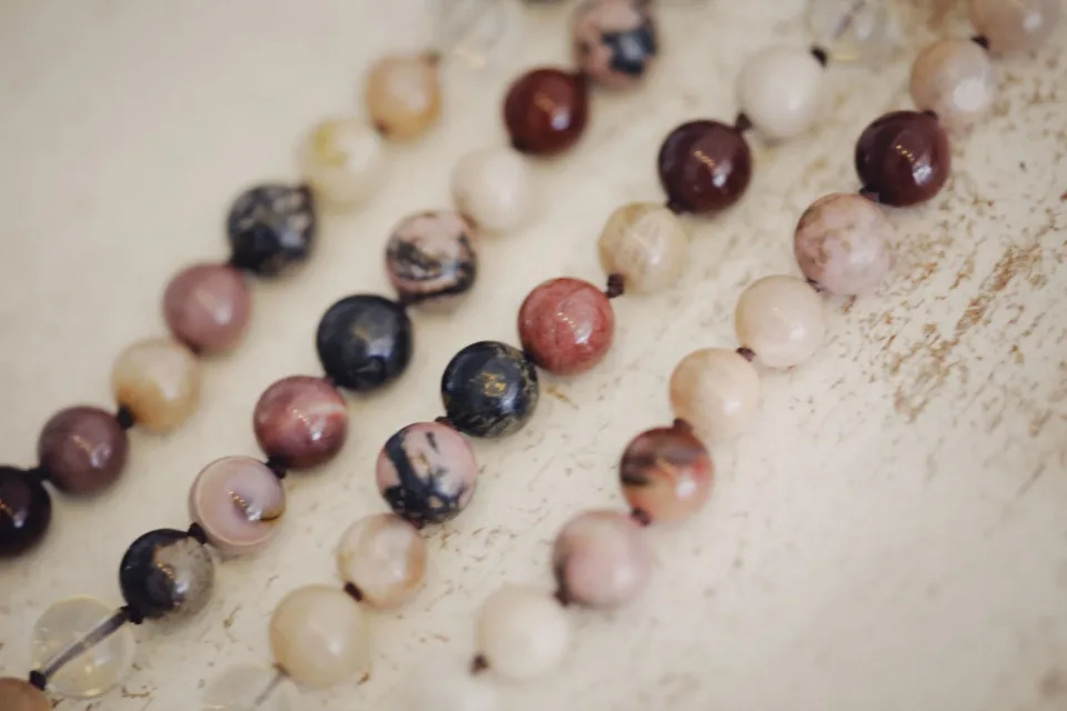 Close view of polished beads in burgundy, cream and charcoal tones